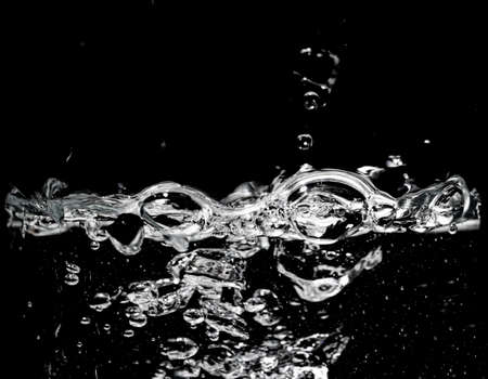 Clear water surface on a black with ripple and bubblesの写真素材