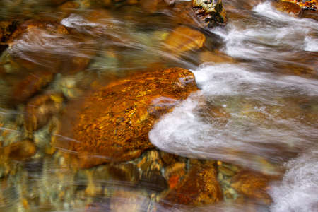long exposure with water passing through brown stonesの写真素材
