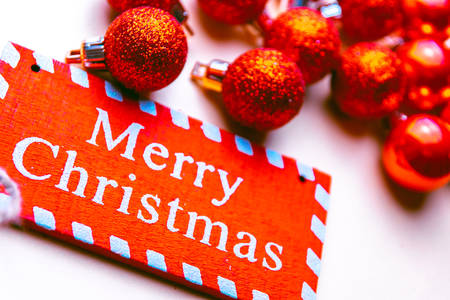 banner on white background surrounded by red balloons on which writes merry christmasの写真素材