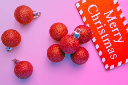 banner on pink background surrounded by red balloons on which he writes merry christmasの写真素材