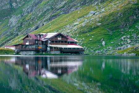 BÃ¢lea Lake in the FÄgÄraÈ Mountains, Sibiu County. Reflection of the cottage in the water of the lake at sunset. Picture taken on August 30th, 2019.のeditorial素材