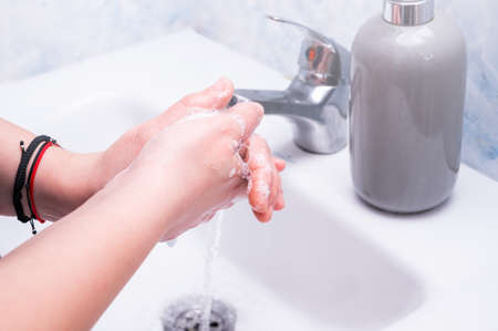 Woman use soap and washing hands under the water tap. Hygiene concept hand detailの写真素材