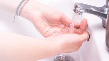 Woman use soap and washing hands under the water tap. Hygiene concept hand detailの写真素材