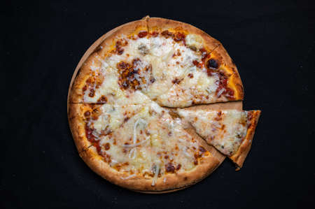 Pizza quatro formaggi with tomato sauce and 4 kinds of cheese on a black background.の写真素材