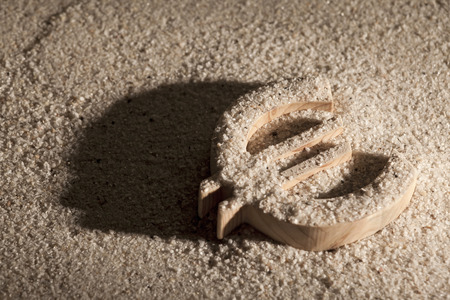 Wooden economy and currency unit in sand with shodowの写真素材