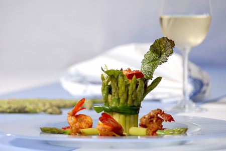 Delicious asparagus dish with a white wine on the tableの写真素材