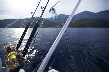 Fishing gears and fisherman boat sailing away in open seaの写真素材