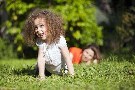 Mother and daughter are enjoying on grass at parkの写真素材