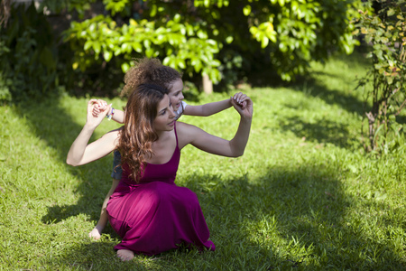 Mother and daughter are enjoying on grass at parkの写真素材