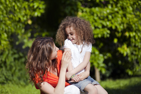 Mother and daughter are enjoying on grass at parkの写真素材