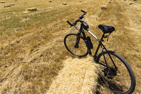 A mountain bike near hay bale in a fieldの写真素材