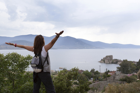 Healthy and happy young woman greets the mountain and seaの写真素材