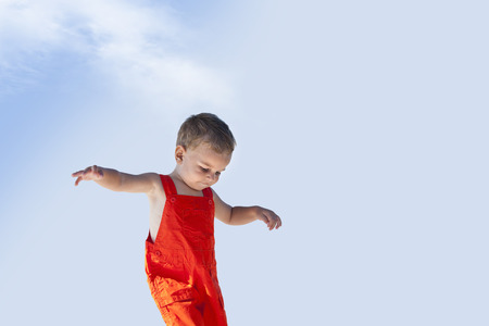 Lovely handsome boy is walking with his orange overallの写真素材