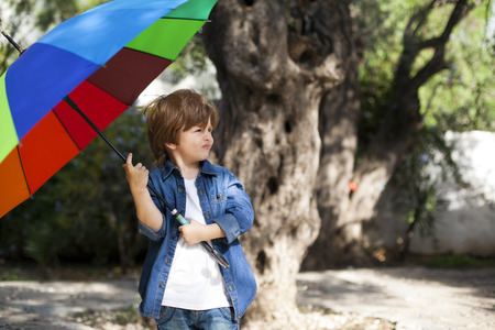 Young boy with umbrella in natureの写真素材