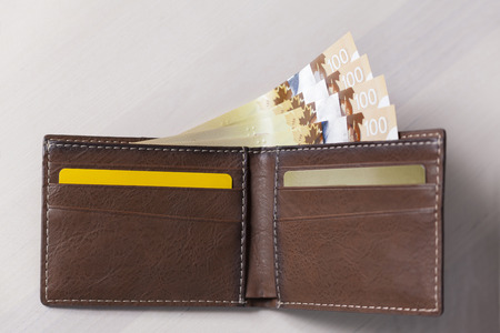 Canadian Dollars and credit cards in brown coloured leather wallet