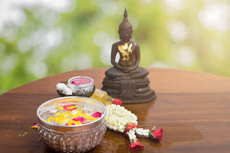 flower float water in bowl for bath buddha statue, songkran festival in thailandの写真素材