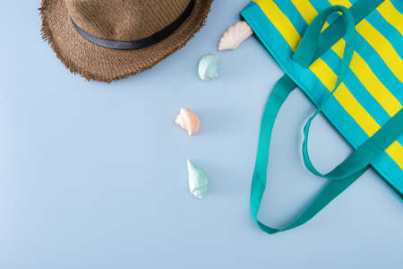 top veiw of travel sea concept have straw hat, nylon bag and soap shell on blue background, flat lay styleの写真素材