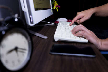 finger press enter button on keyboard, working of business man at nightの写真素材