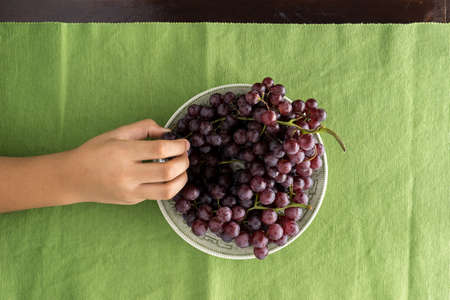top view of hand picked grape in dish on the tableの写真素材