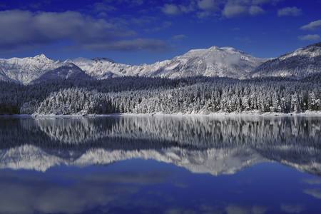 mountains reflected in the eibsee lake in the winterの写真素材