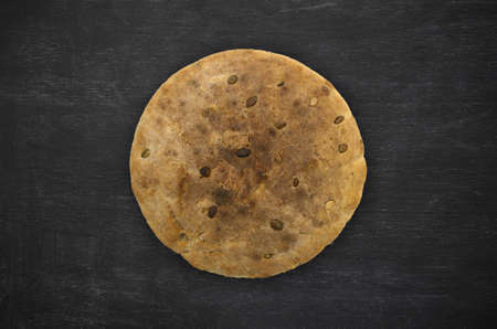 home made bread with pumpkin seeds on black painted wood