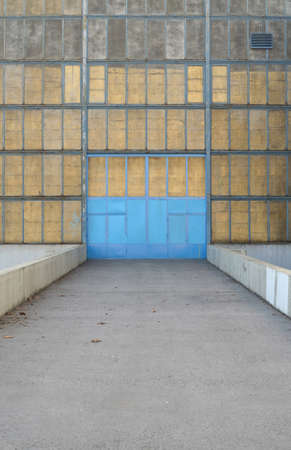 old industrial building with blue metal doorの写真素材