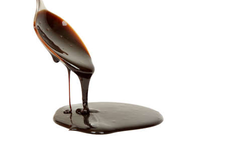 chocolate syrup dripping from spoonの写真素材