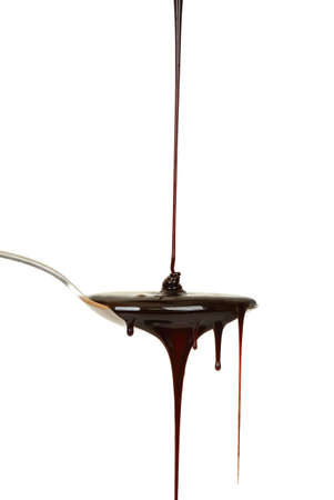 chocolate syrup dripping from spoonの写真素材