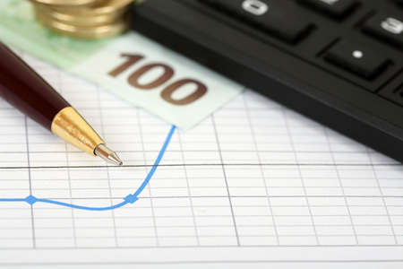 pen, money and calculator on graphの写真素材