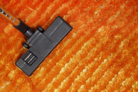 vacuum cleaner on orange carpetの写真素材