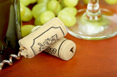 bottle corks on wood next to a wine bottle の写真素材