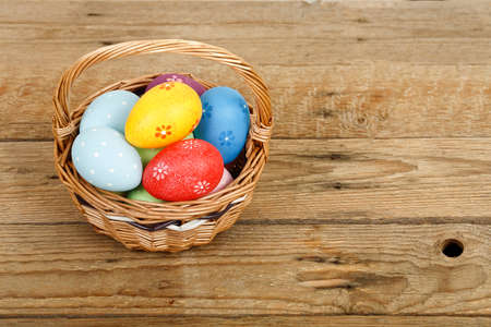 easter eggs in basket on wooden surfaceの写真素材