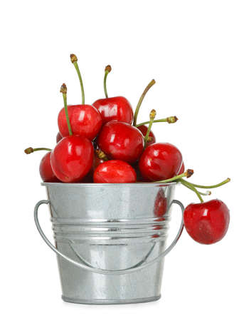 tin bucket with cherries isolated on whiteの写真素材