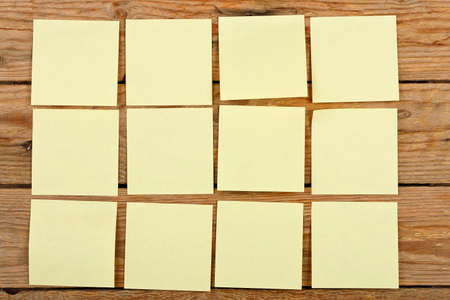 twelve yellow paper  notes on wooden planks