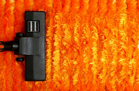 vacuum cleaner on orange fluffy carpetの写真素材