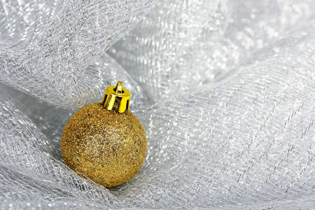 golden xmas ball on shiny meshの写真素材