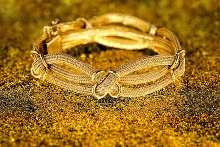 antique gold bracelet on sparkling surfaceの写真素材
