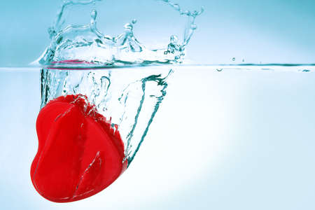 red heart sinking in water closeupの写真素材