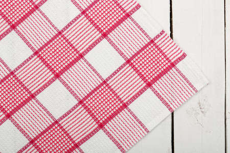 checked napkin over old white wooden planksの写真素材