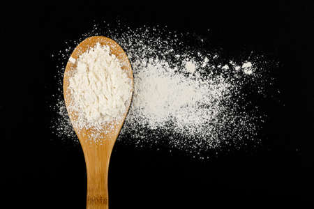 ladle with flour on black surfaceの写真素材