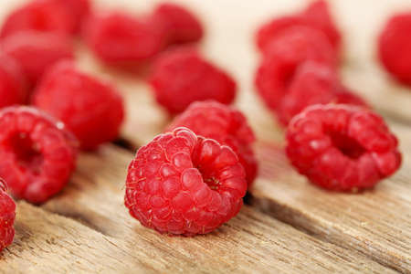 macro of ripe raspberries on weathered wood