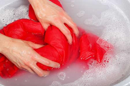 woman washing delicate clothes by hands in plastic tubの写真素材