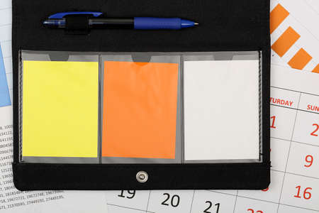 organizer with blank notes on calendar and graphsの写真素材
