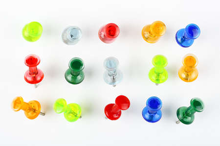 variety of colorful pushpins pinned on white paperの写真素材