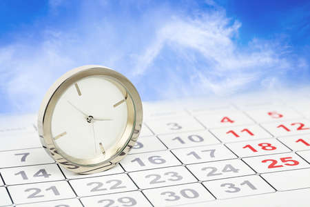 chrome clock on calendar against blue sky