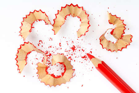 sharpened red pencil with shavings on white paperの写真素材