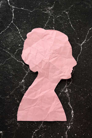 crumpled paper head on cracked black background, abstract conceptの写真素材