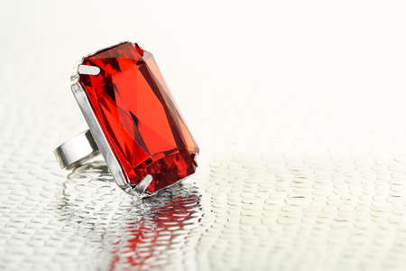 ring with red gemstone on shiny surface