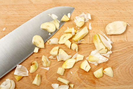 knife with chopped garlic on cutting boardの写真素材