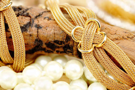 closeup of gold bracelet on weathered piece of wood